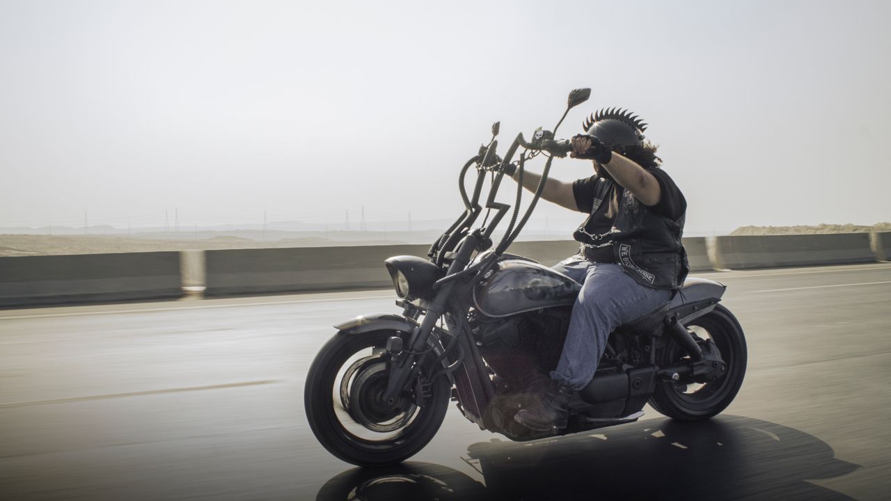 Crafting Captivating Headlines: Your awesome post title goes here Rider on a custom motorcycle cruising down a highway, showcasing freedom and adventure.